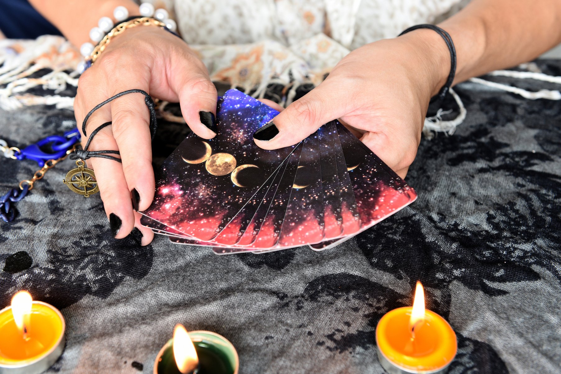 Fortune Teller's Hands Holding Tarot Cards with Candlelight